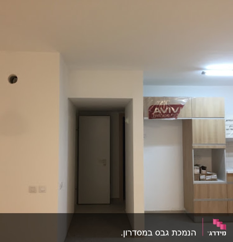 קיר גבס לבן עם חור עגול ותאורה תלויה